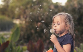 Маленькая девочка с одуванчиком в руках 