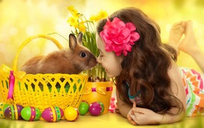 Маленькая девочка с кроликом в корзине на праздник Пасха