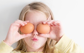 Маленькая девочка с яйцами в руках