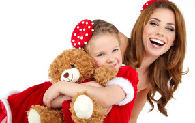 Маленькая девочка с мамой обнимает игрушечного медвежонка