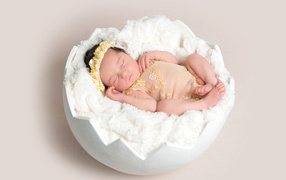 Маленькая новорожденная девочка в забавной колыбели