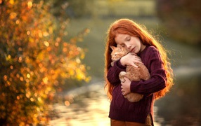 Маленькая рыжеволосая девочка с котенком на руках