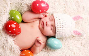 Маленький спящий ребенок с пасхальными яйцами
