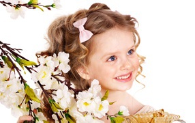 Little smiling girl with a flowering branch