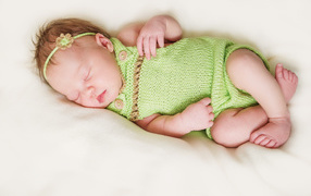Sleeping baby in knitted clothes