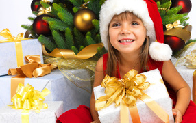 Улыбающаяся девочка в новогоднем костюме с подарками под елкой
