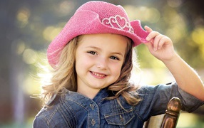 Улыбающаяся девочка в розовой шляпе