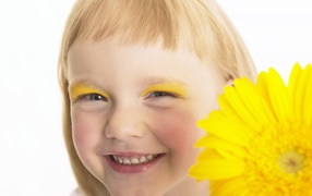 Улыбающаяся девочка с желтым цветком герберы