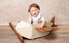 Улыбающийся маленький мальчик в игрушечном самолете