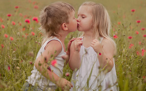 The first kiss of a boy and a girl on a flowering field