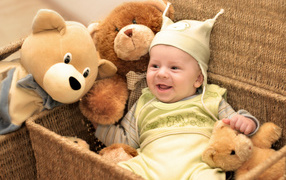 Грудной улыбающийся ребенок в корзине с игрушками