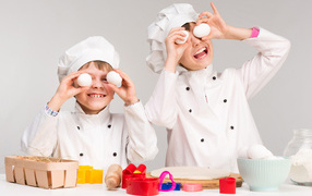 Два маленьких мальчиках в костюмах повара на кухне