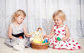 Две маленькие девочки с корзиной пасхальных яиц