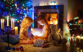 Две маленькие девочки с игрушками у камина