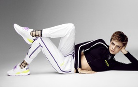 Актриса Кара Делевинь в спортивном костюме на сером фоне