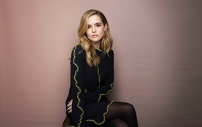 Актриса Зои Дойч в красивом платье сидит на стуле 