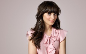 Актриса Зоуи Дешанель в розовом платье на сером фоне