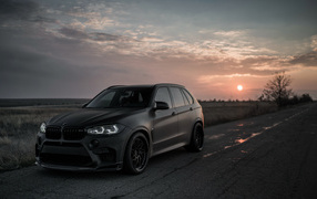Crossover BMW X5 M, 2018 against the sunset
