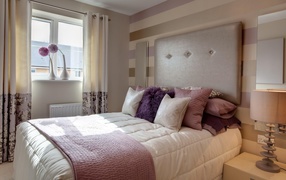 Большая кровать с подушками в спальне 