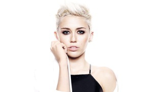 Популярная исполнительница Майли Сайрус с короткой стрижкой на белом фоне