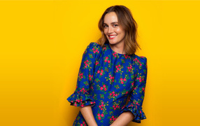 Улыбающаяся актриса Лейтон Мистер в красивом платье на желтом фоне 