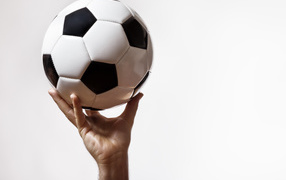 Soccer ball in hand on a white background