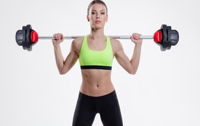 Спортивная девушка со штангой на плечах