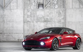 Красный автомобиль Aston Martin Vanquish, 2019 года на фоне серой стены