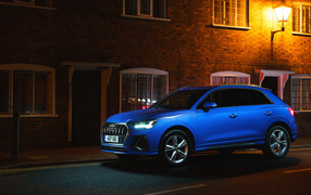Синий автомобиль Audi Q3 35 TFSI S Line на фоне здания вечером