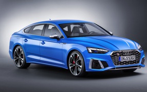 Синий автомобиль Audi S5 Sportback TDI 2019 года на сером фоне