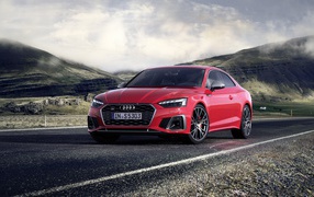 Stylish red Audi S5 Coupe TDI 2019 on a background of hills