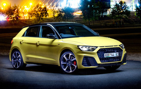 Желтый автомобиль Audi A1 Sportback 40 TFSI S Line Edition One 2019 года на фоне ночного города