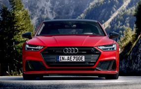 Красный автомобиль Audi A7 Sportback 55 TFSI E Quattro S Line 2019 года на трассе 