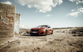 Красный автомобиль BMW 8 под голубым небом