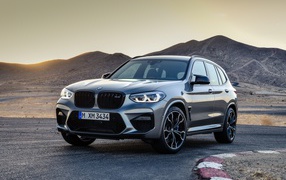 Серебристый автомобиль BMW X3  на асфальте