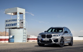 Серебристый автомобиль BMW X3 на асфальте