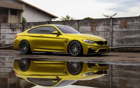 Желтый автомобиль BMW M5 отражается в воде 