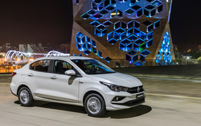 Белый автомобиль Fiat  Cronos, 2018 года на фоне здания