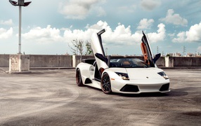 Белый автомобиль Lamborghini Murcielago с открытыми дверями
