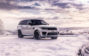 Серебристый внедорожник Range Rover Sport стоит на снегу
