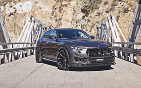 Внедорожник Maserati Levante на мосту на фоне гор