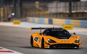 Оранжевый спортивный автомобиль McLaren 720S GT3 на гоночной трассе 