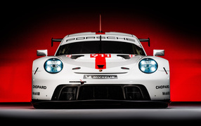 Спортивный автомобиль Porsche 911 RSR 2019 года на красном фоне