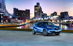 Стильный синий автомобиль Renault Captur на фоне города