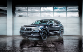 Черный автомобиль Volkswagen Touareg 2018 года у гаража