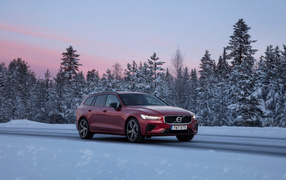 Красный автомобиль Volvo V60 на зимней дороге