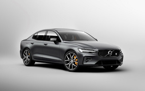 Серебристый автомобиль Volvo S60, 2018 года на сером фоне