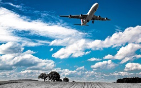 Самолет авиакомпании Swiss Airlines в небе с белыми облаками