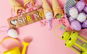 Надпись весна с вафельными рожками и яйцами на розовом фоне