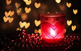 Зажженная свеча на столе с бусами 